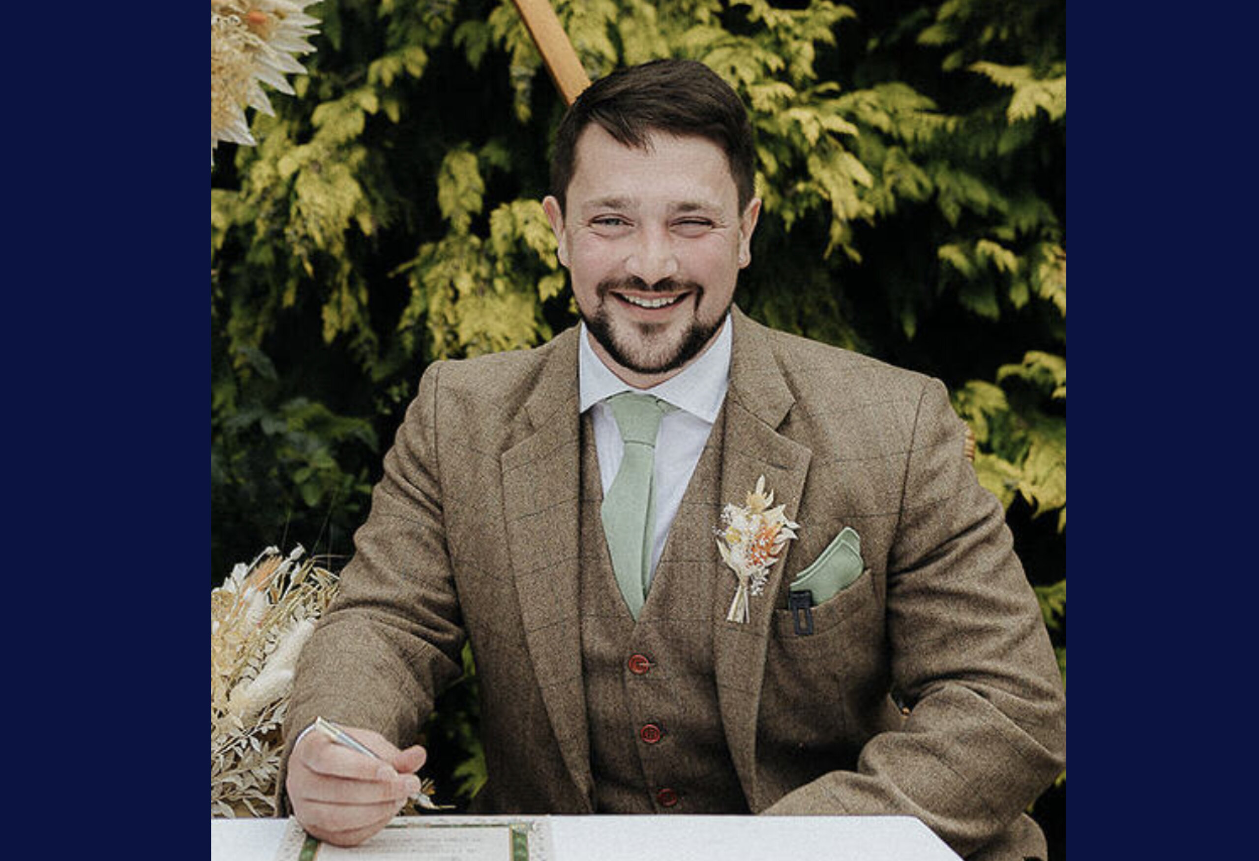 A photograph of Simon Blundell wearing a brown suit